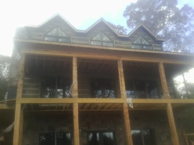 Dormers and porch framing on a large log home under construction — Roof Coating work by our crew in Azalea