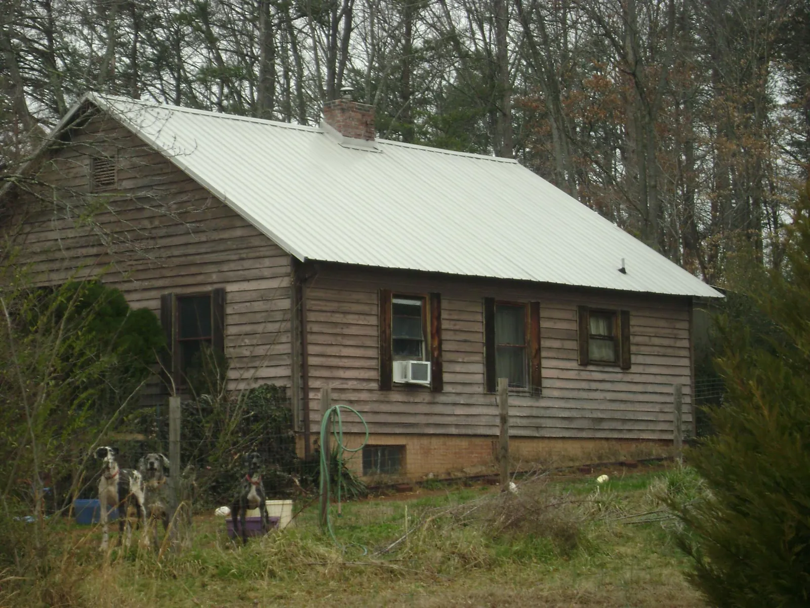 White metal roof on an old wood sided farmhouse, from a Metal Roof Installation job in Azalea